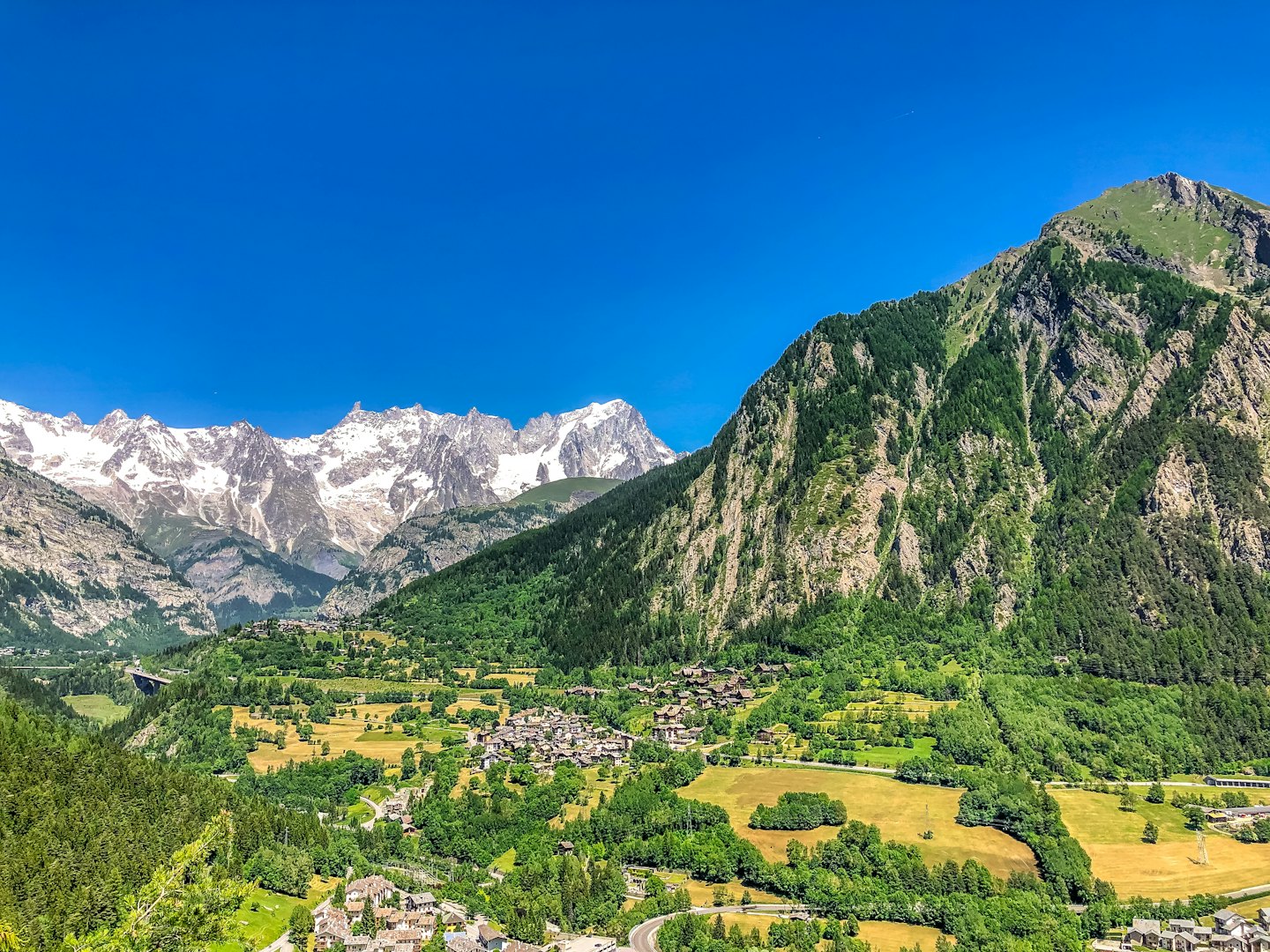 Alpine village nestled in a lush green mountain valley.